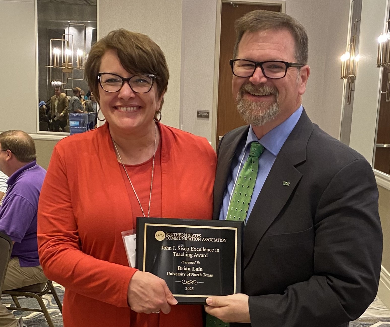 Dr. Lain holding John L. Sisco award with woman beside him holding it also
