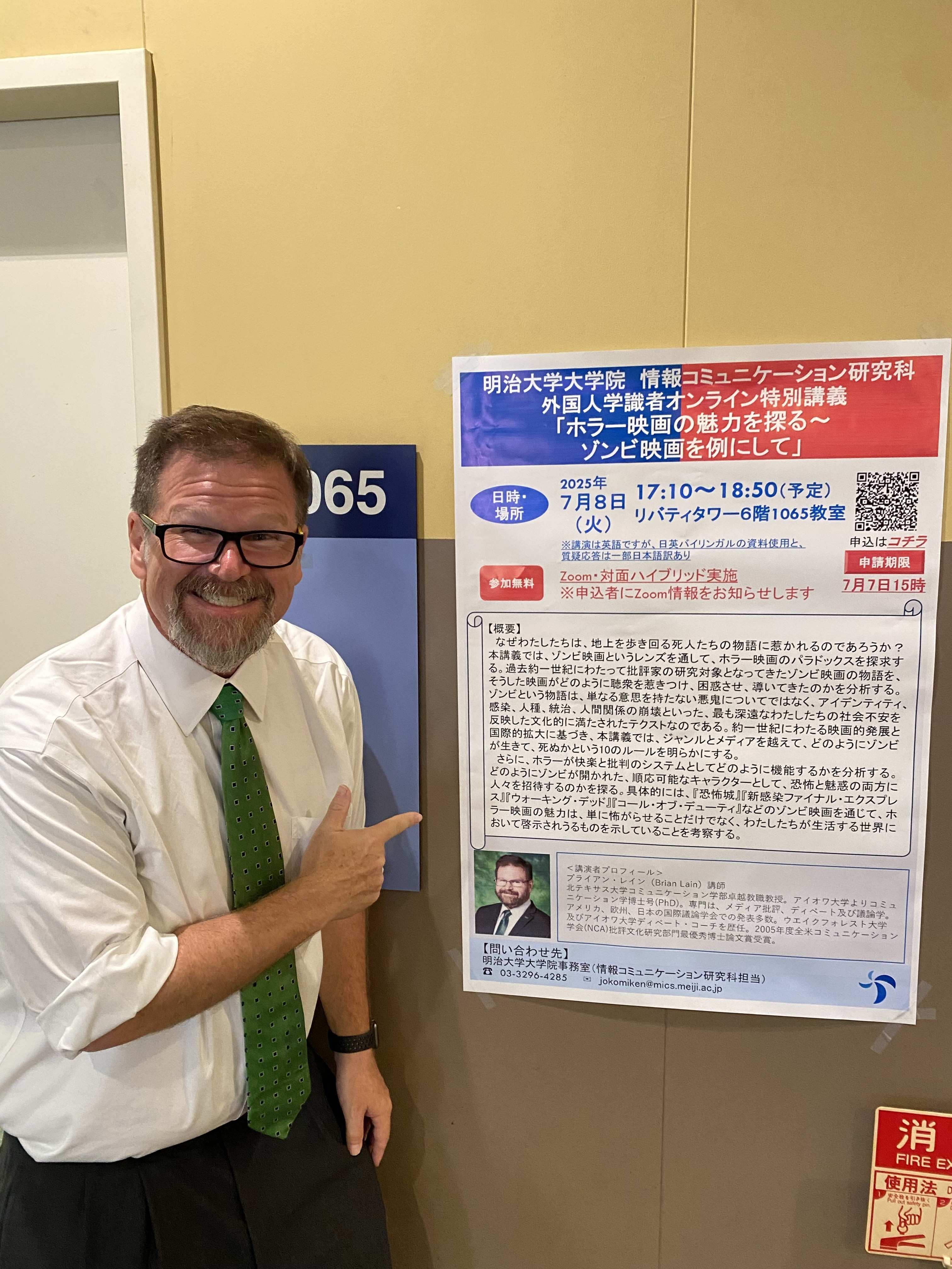 Dr. Lain posing with poster advertising his lecture