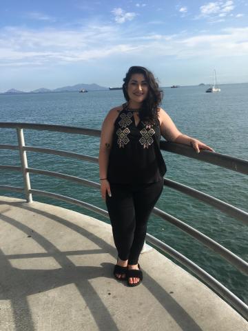 Morgan Cheramie standing on the deck of a boat with the ocean and mountains in the background.